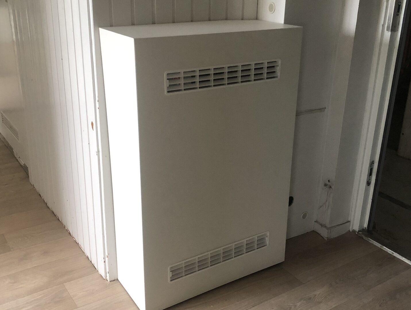 Voorzijde van de CV afwerkkoof, met geïntegreerde roosters tbv. warmteafvoer 